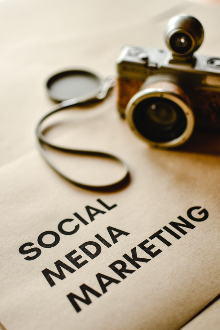 about-us-01 Close-up of a vintage camera on brown paper labeled with Social Media Marketing.